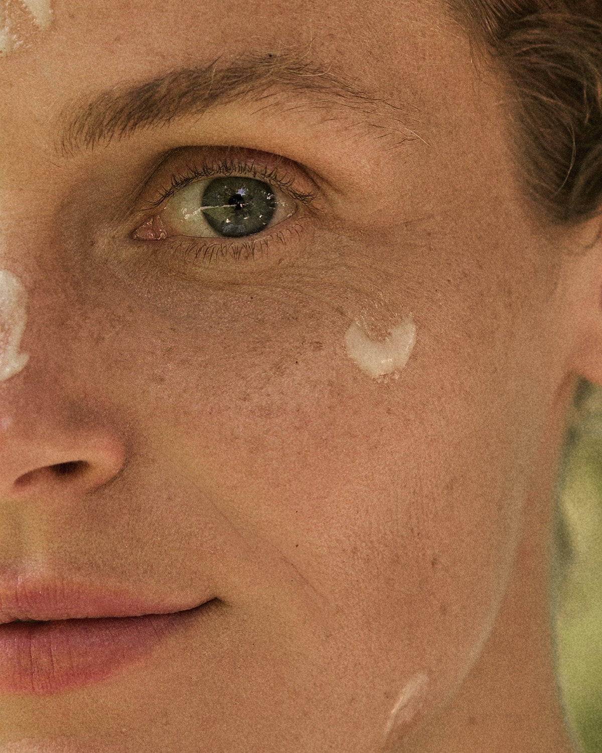 Close-up of the eye area with a dab of eye cream on the skin under the eye
